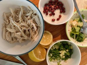 All ingredients for lemon shredded chicken breast arranged on a board