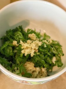 Minced scallion, ginger, garlic, sesame seeds, and chili powder in a bowl