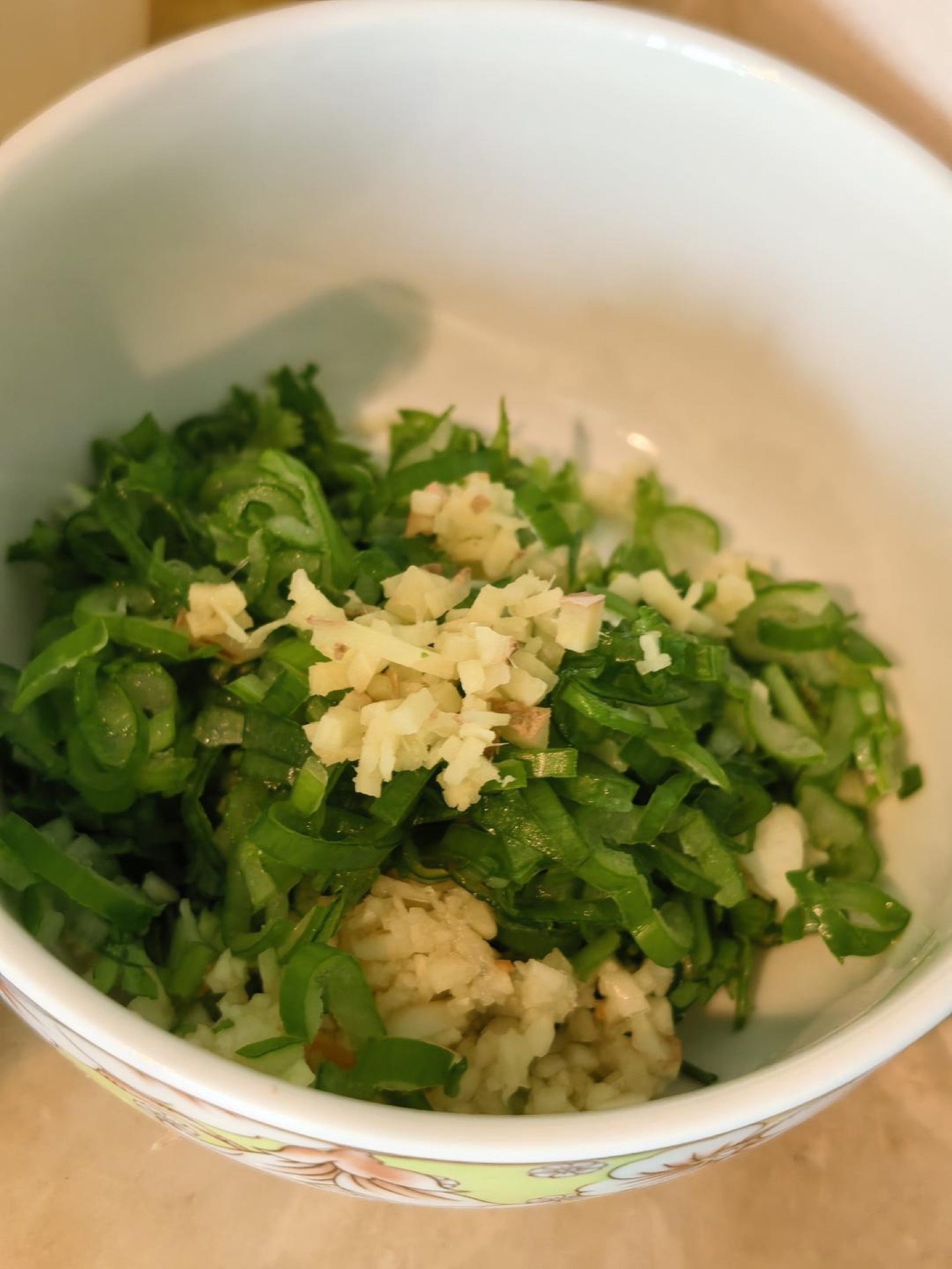 Minced scallion, ginger, garlic, sesame seeds, and chili powder in a bowl