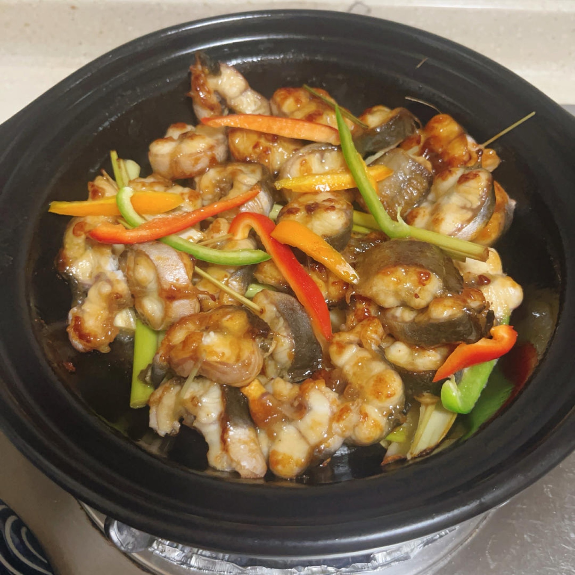 Lemongrass baked eel in a clay pot, garnished with fresh lemongrass
