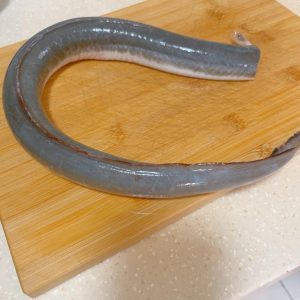 Blanching the eel to remove surface mucus