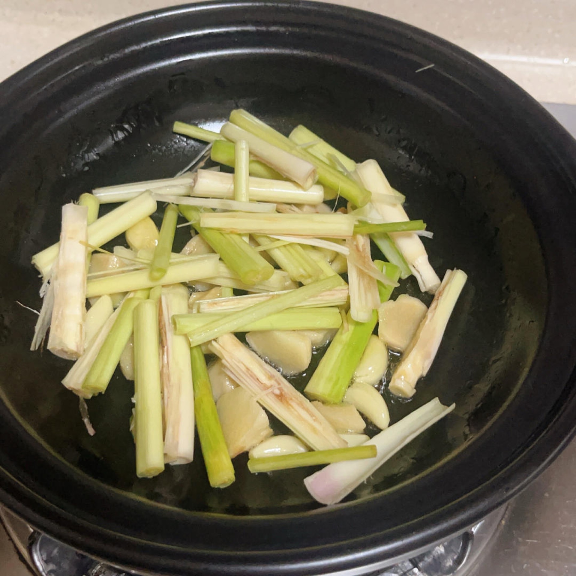 Lemongrass layered in the bottom of the clay pot