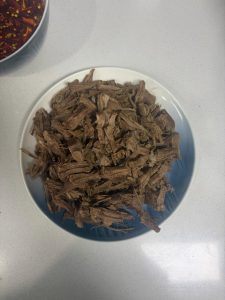 Once the beef has cooled, tear it along the grain into strips (this part takes some patience).