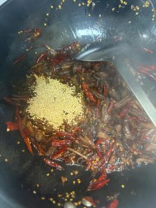 After removing the aromatics, add the shredded beef to the wok and stir-fry for 2-3 minutes, then add the soaked chilies and Sichuan peppercorns. After a few stirs, lower the heat