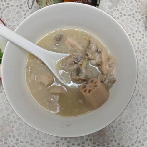 Lotus Root Pork Rib Soup (排骨藕汤) served in a white bowl with visible pork ribs and lotus root coins