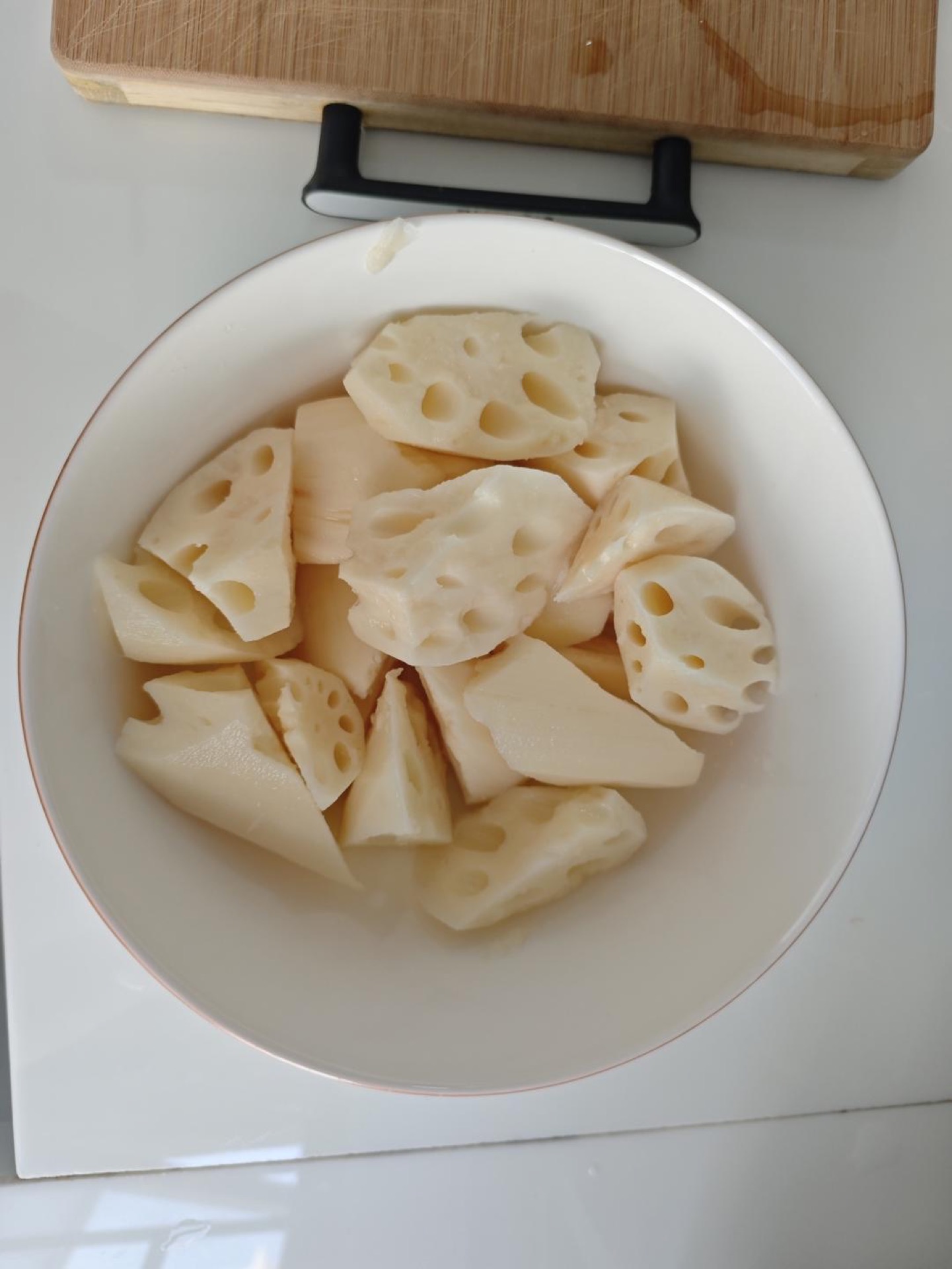 Lotus root chunks tossed with salt and sugar in a bowl