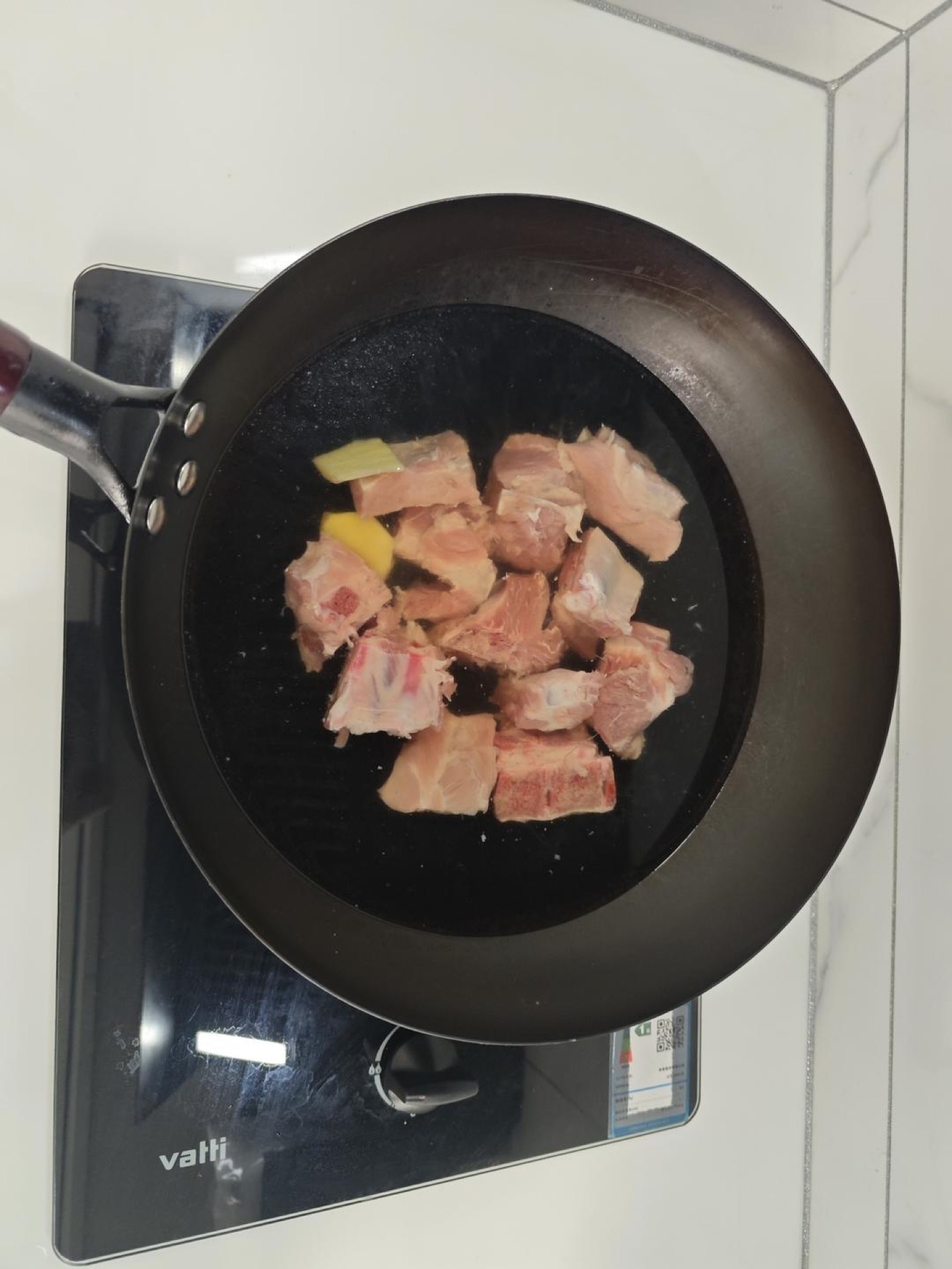 Pork ribs blanching in a pot with ginger and wine