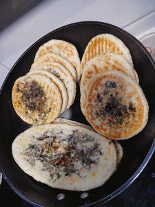 A whole batch of golden mei cai pork pancakes
