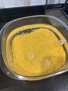 Dried mung beans soaking in a bowl of water