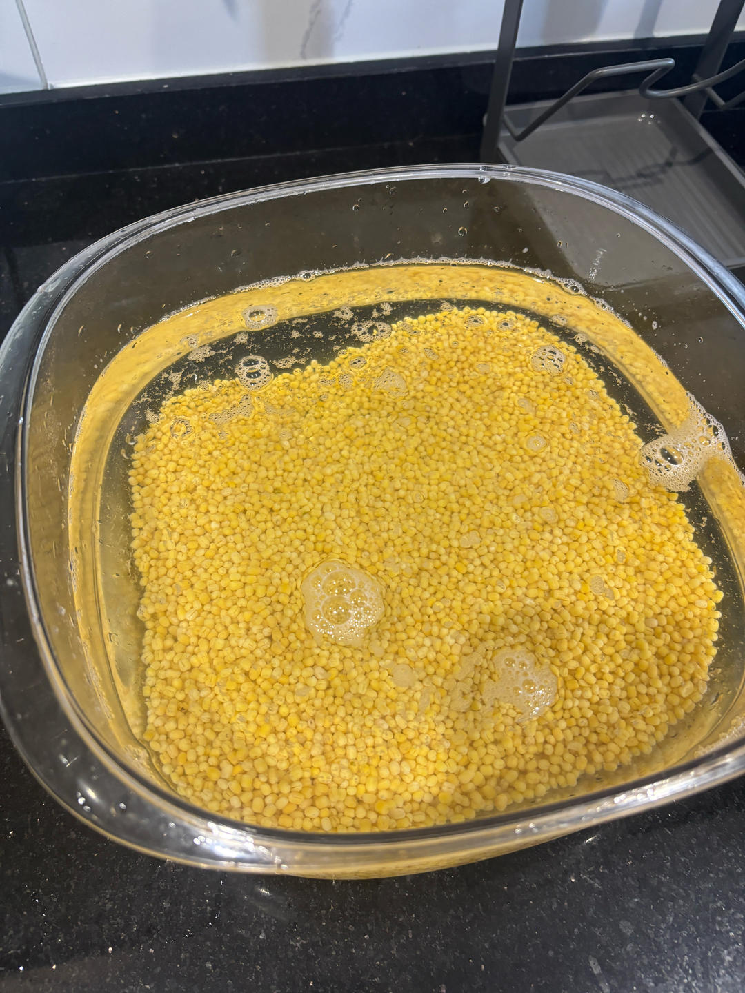 Dried mung beans soaking in a bowl of water