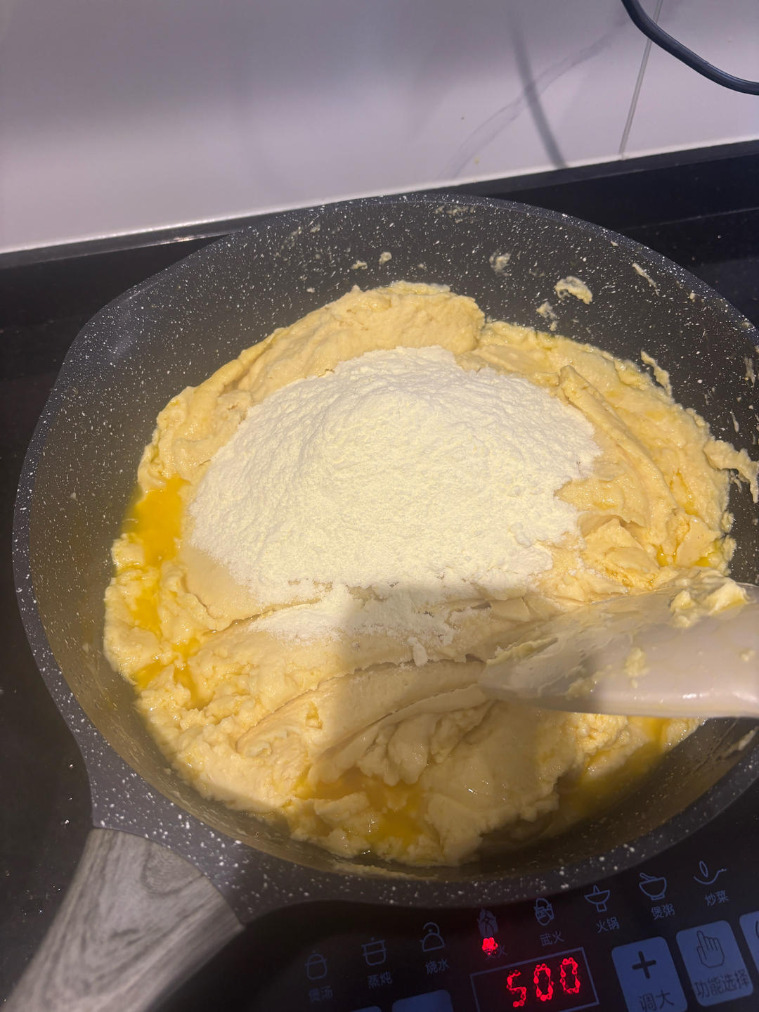 Mung bean paste being cooked down in a wide pan