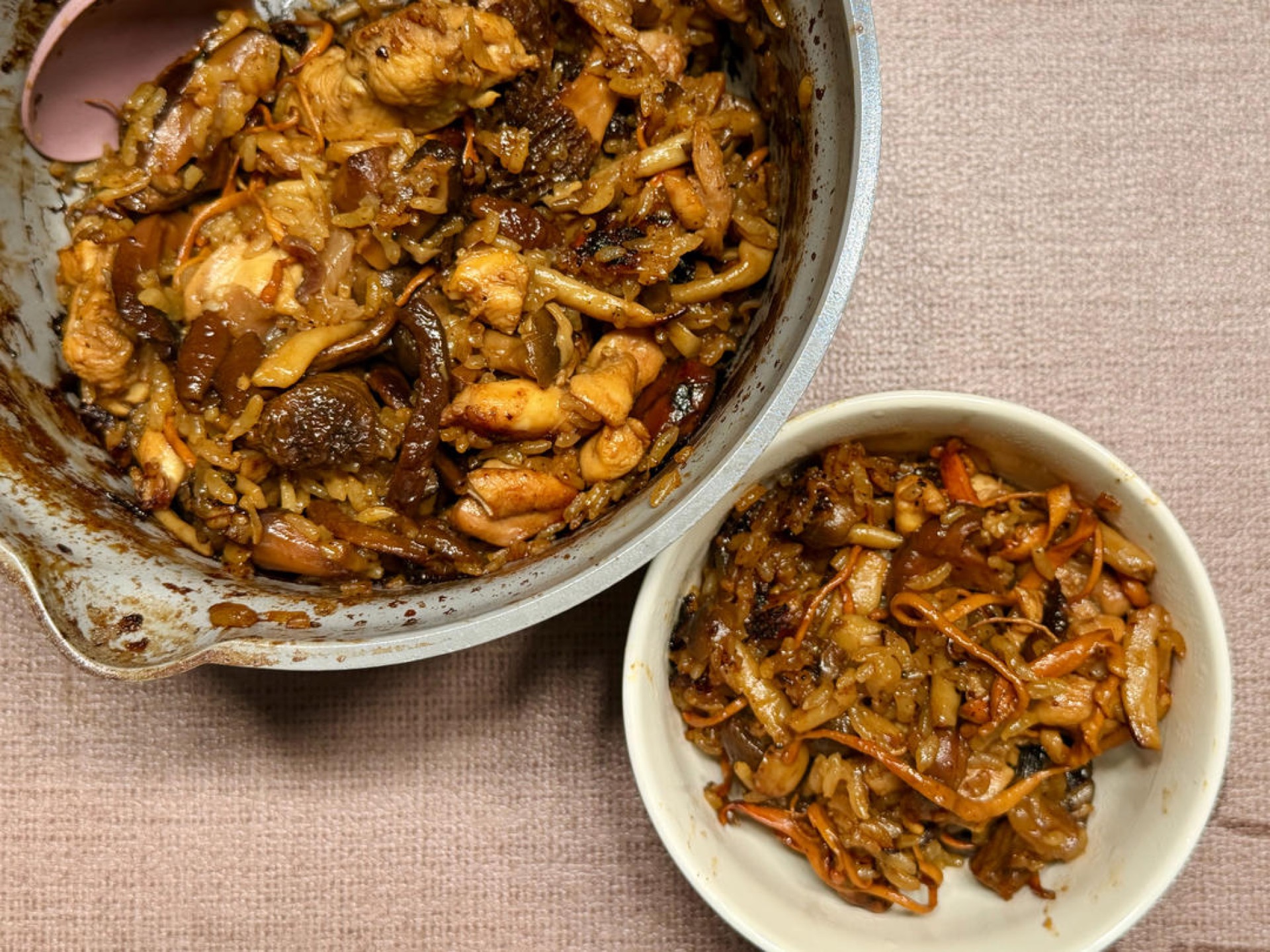 Mushroom chicken claypot rice in a wok, garnished with scallions