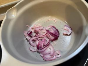 Heat the wok over medium heat, spray or add a little oil, and stir-fry the sliced onion until it softens and turns translucent.