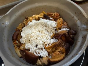 Add the drained, soaked rice to the wok with the chicken and mushrooms.