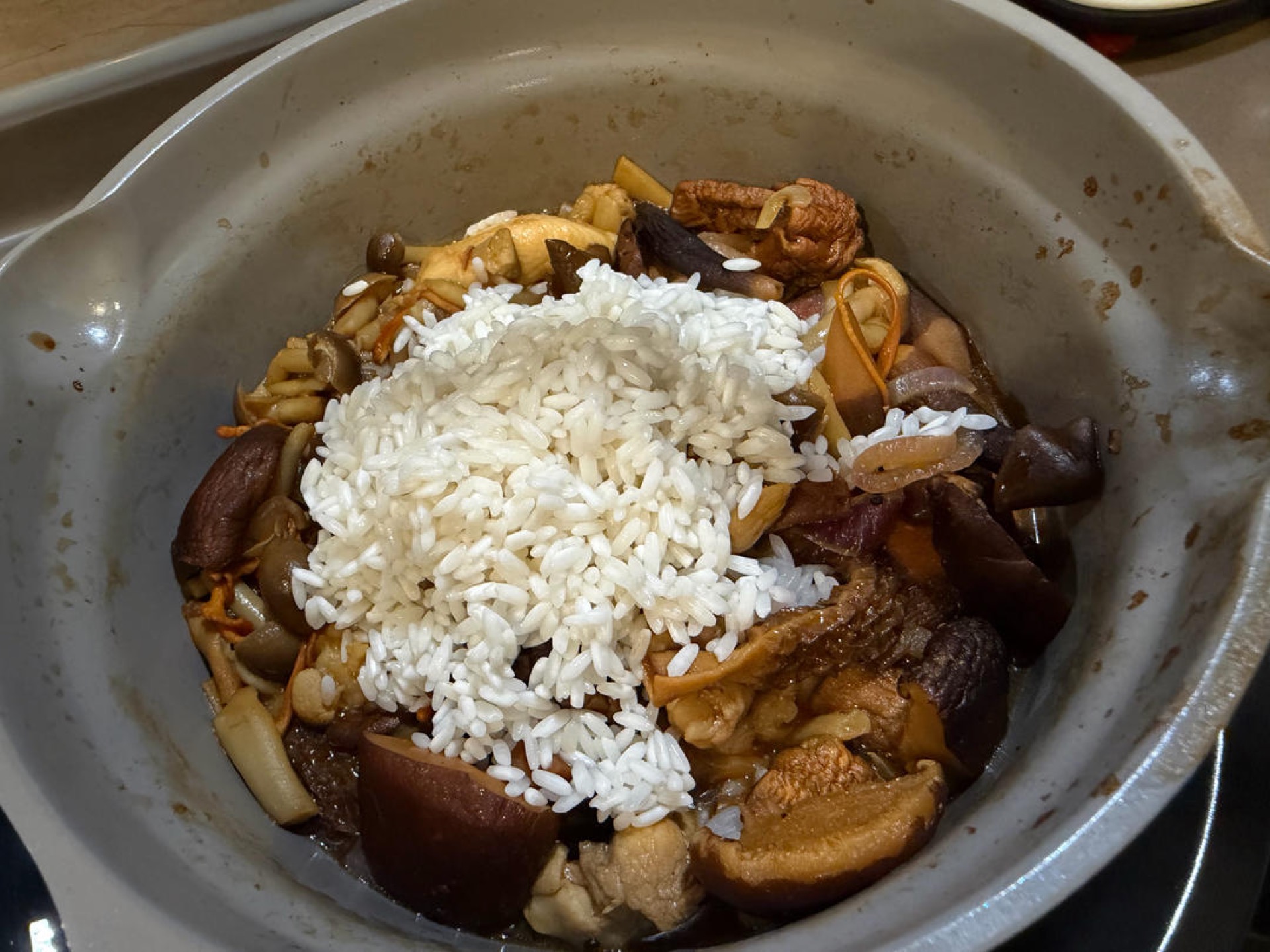 Add the drained, soaked rice to the wok with the chicken and mushrooms.