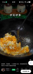 Scrambling the eggs into fluffy curds in the wok