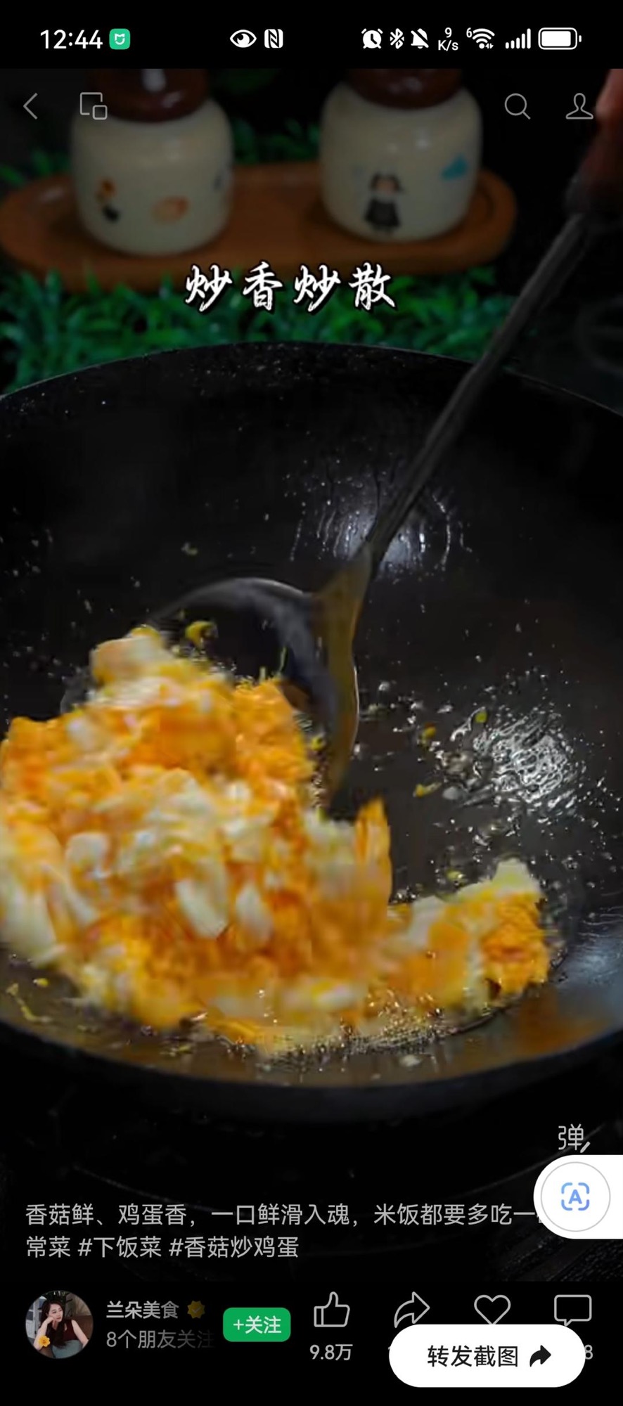 Scrambling the eggs into fluffy curds in the wok