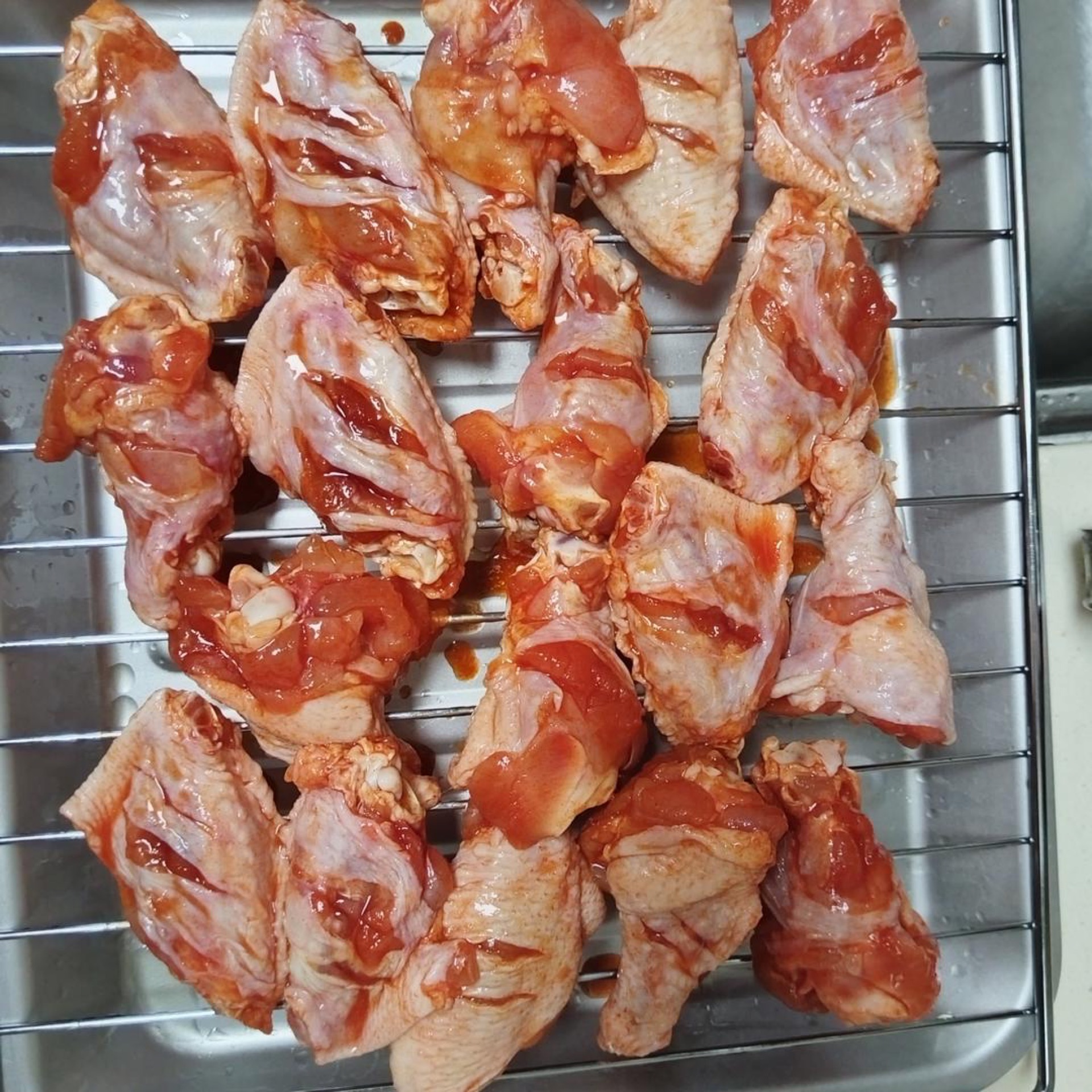 Before the wings go into the oven, brush the wire rack with a thin layer of oil, then brush a coat of honey over each drumette and mid-joint.