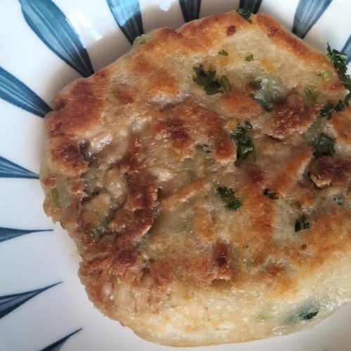 Golden pan-fried no-knead meat pies stacked on a plate with a crispy crust
