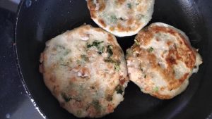 Golden crispy no-knead meat pies finishing in the skillet