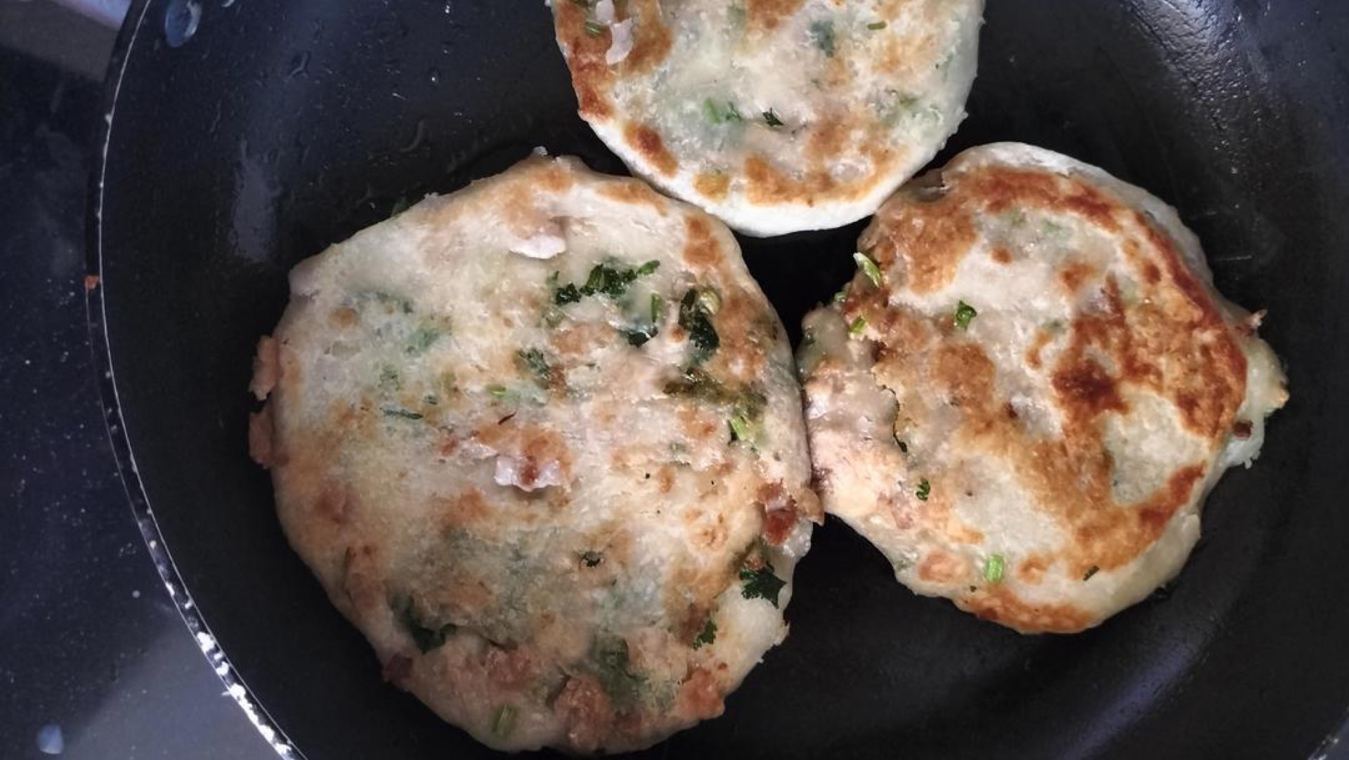 Golden crispy no-knead meat pies finishing in the skillet