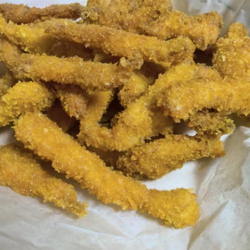 Orleans-style chicken tenders piled on a plate, golden and crisp