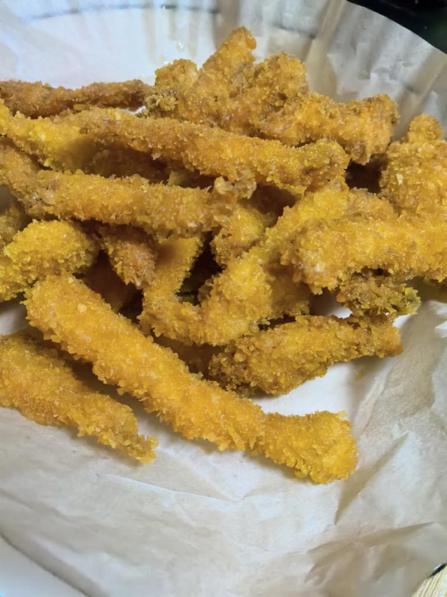 Orleans-style chicken tenders piled on a plate, golden and crisp