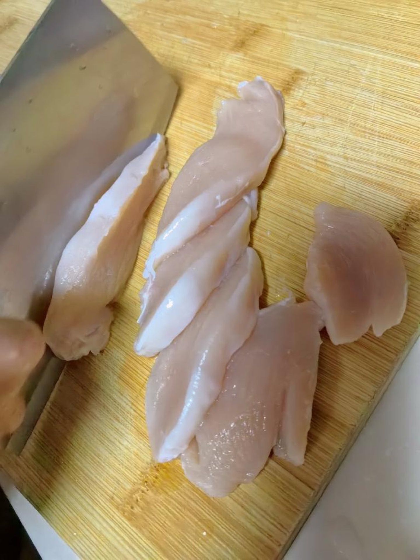 Remove the sinew from the chicken breast, slice it into pieces about 1 cm thick, then cut them into strips the width of a pinky finger.