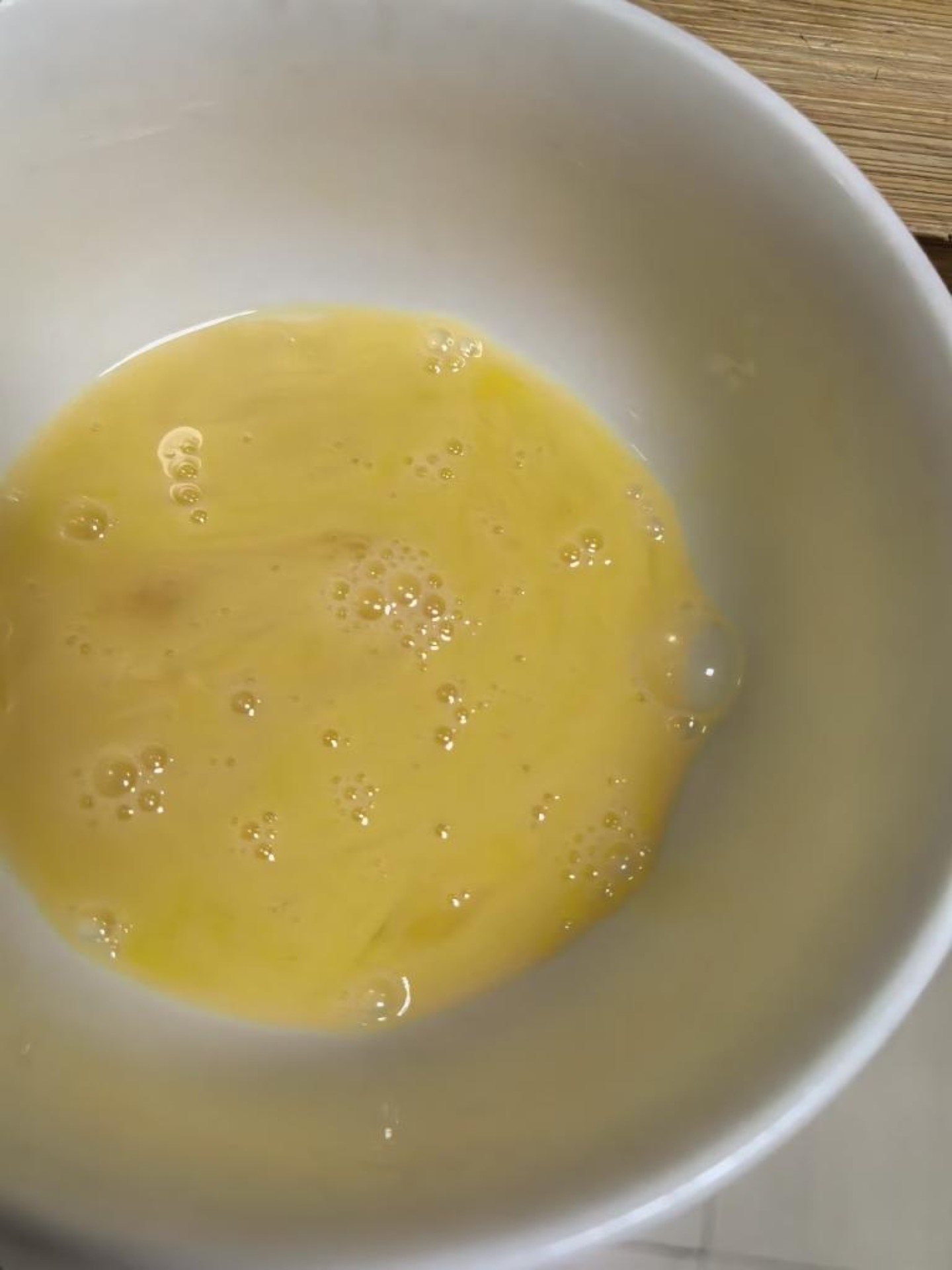 Roll the starch-coated strip through the beaten egg.