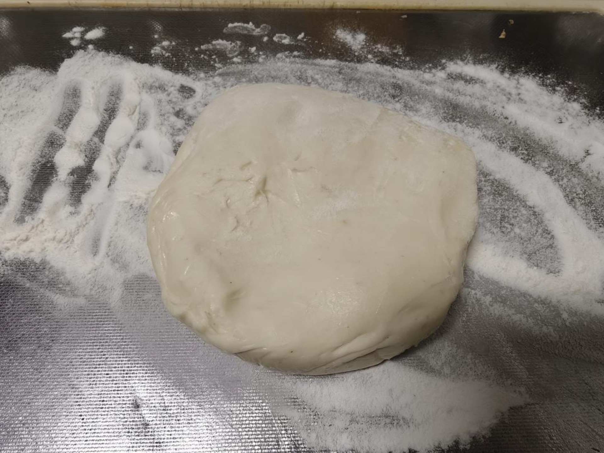 Next, sprinkle dry flour over the cutting board and put the dough on the board. If the dough is too big, cut it into smaller pieces.