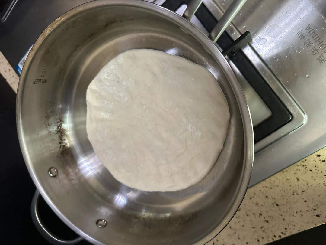 Dough being pressed again into an even round