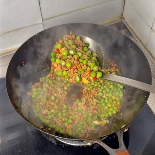 Saucy minced pork with peas in a bowl over rice