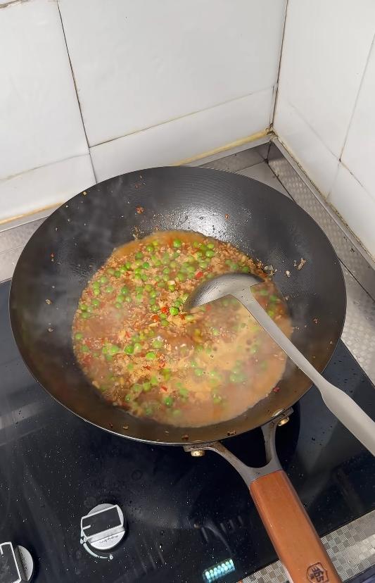 Adding water and seasonings to the peas and pork