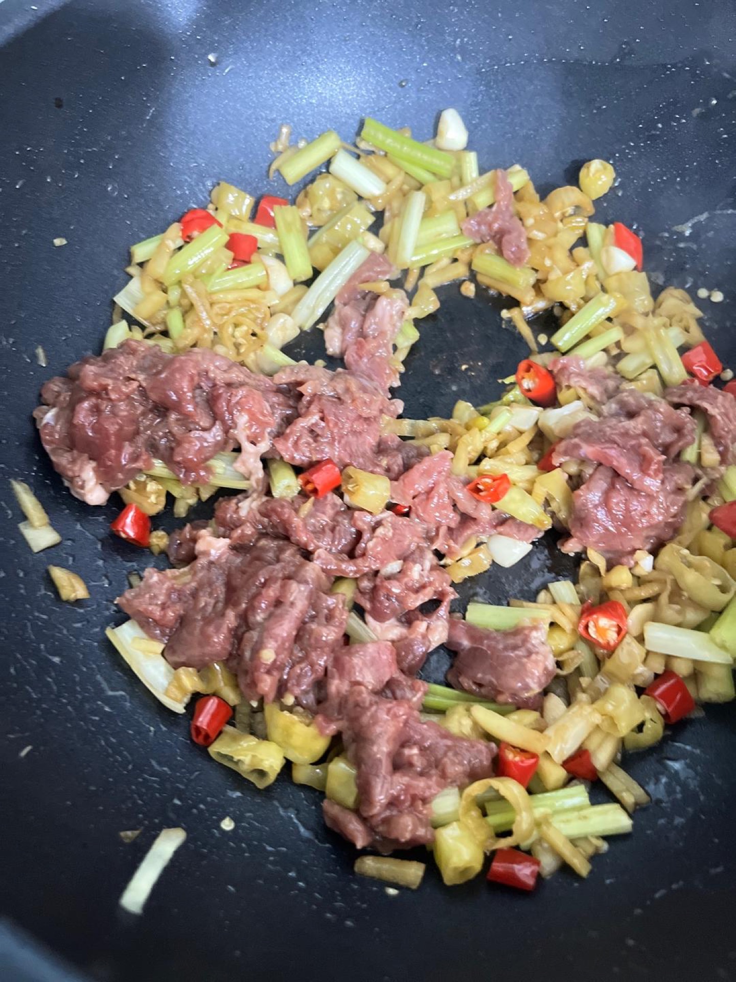 Add the marinated beef and stir-fry over high heat, spreading it out so every slice makes contact with the hot wok.