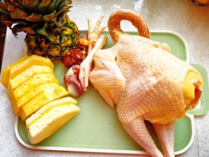 Ask the fruit shop to cut the pineapple for you — a half-moon slice works well. My chicken weighed about 2 lb (900 g) and the pineapple was just under 3 lb (1.4 kg); size the bird