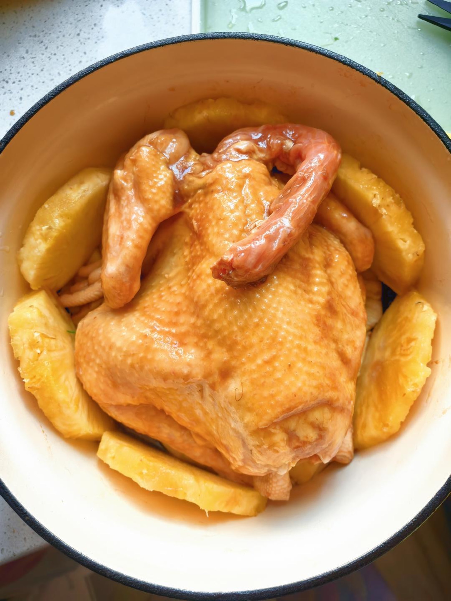 Place the chicken on top, arrange a ring of pineapple around it, and pour all the marinade over the chicken.