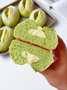 A torn piece of bread showing the creamy filling inside