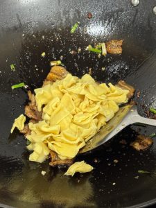 Bamboo shoots added to the wok with the pork