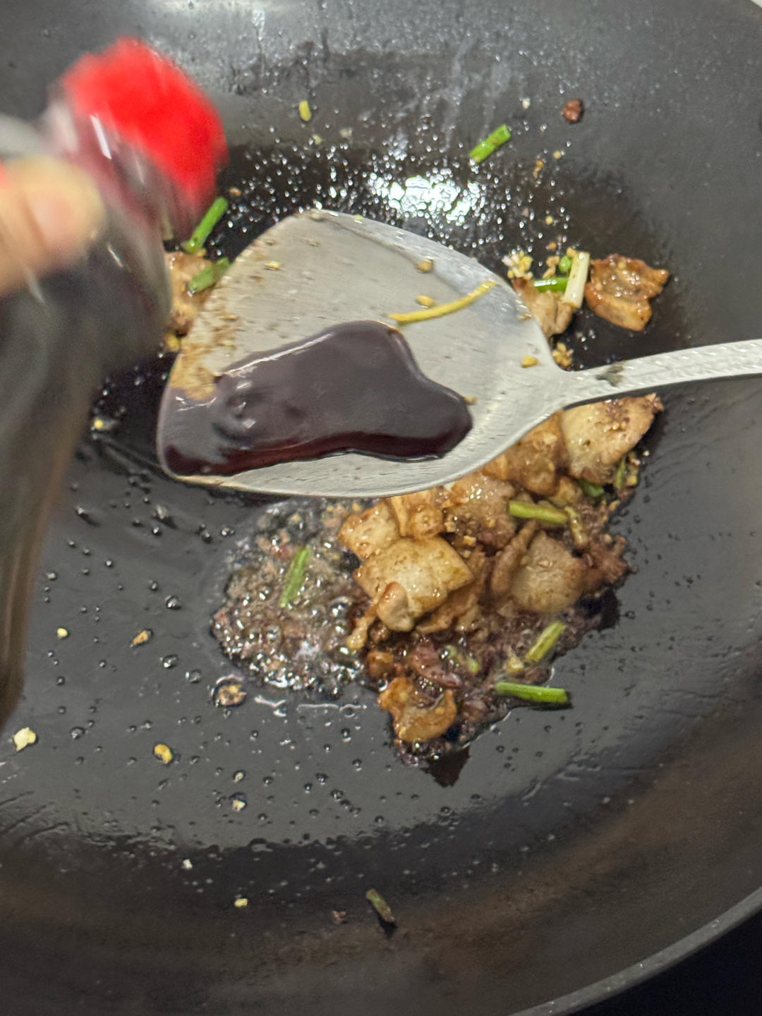 Light soy sauce being stirred into the pork