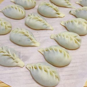 Pork shrimp fennel dumplings arranged on a plate, freshly steamed and ready to serve