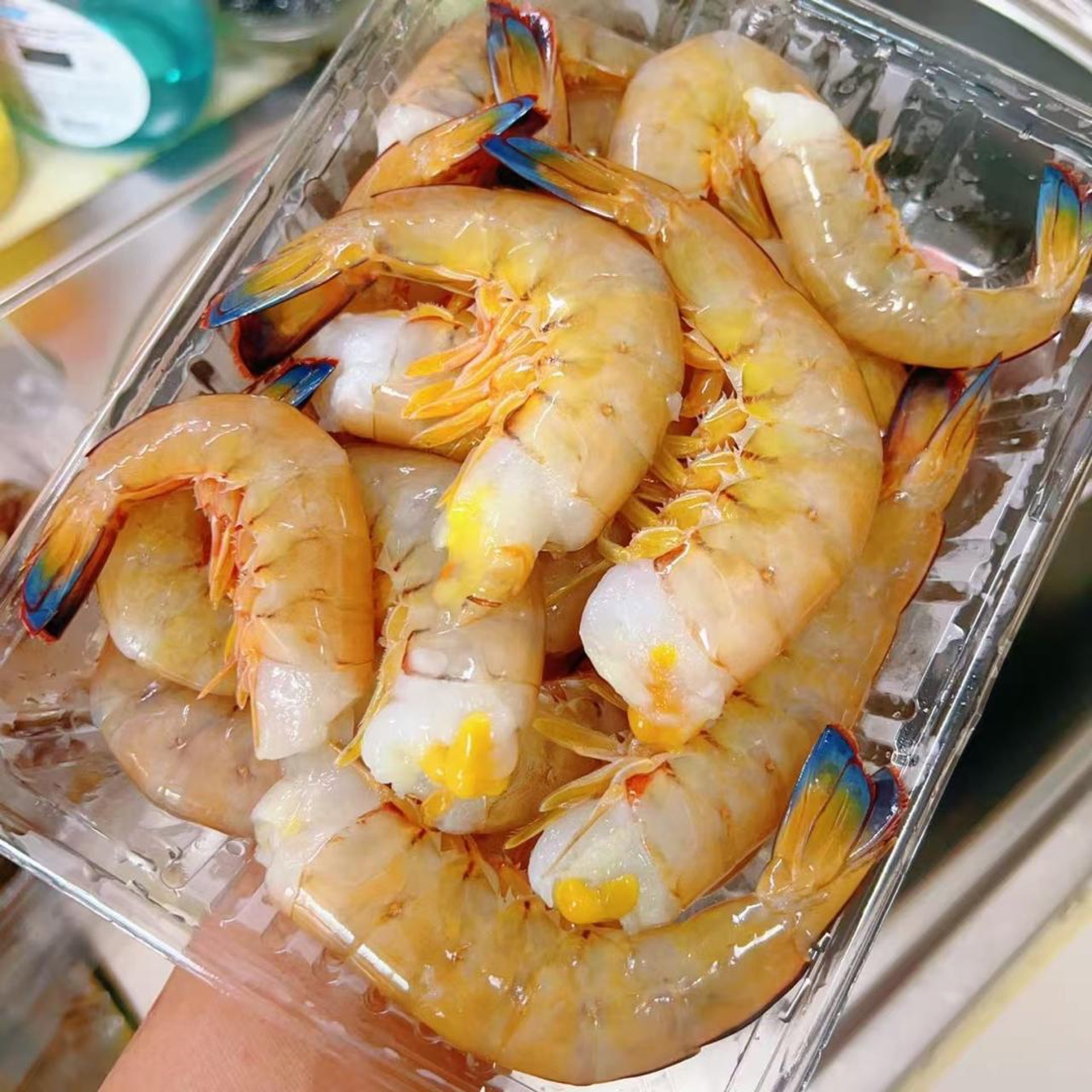 Twist the head off each blue-tail shrimp and pull gently so the head and the digestive tract come away together.