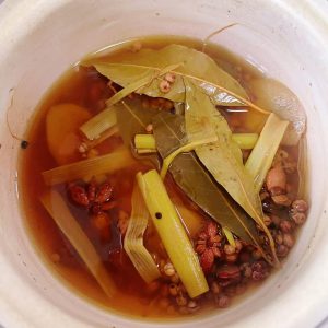 Simmer 2 pieces of scallion, 20 g sliced ginger, 4 star anise, 2 tsp Sichuan peppercorns, 4 bay leaves, and water until fragrant and the liquid turns brown; turn off the heat and l