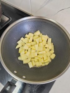 Potato cubes browning in a hot pan