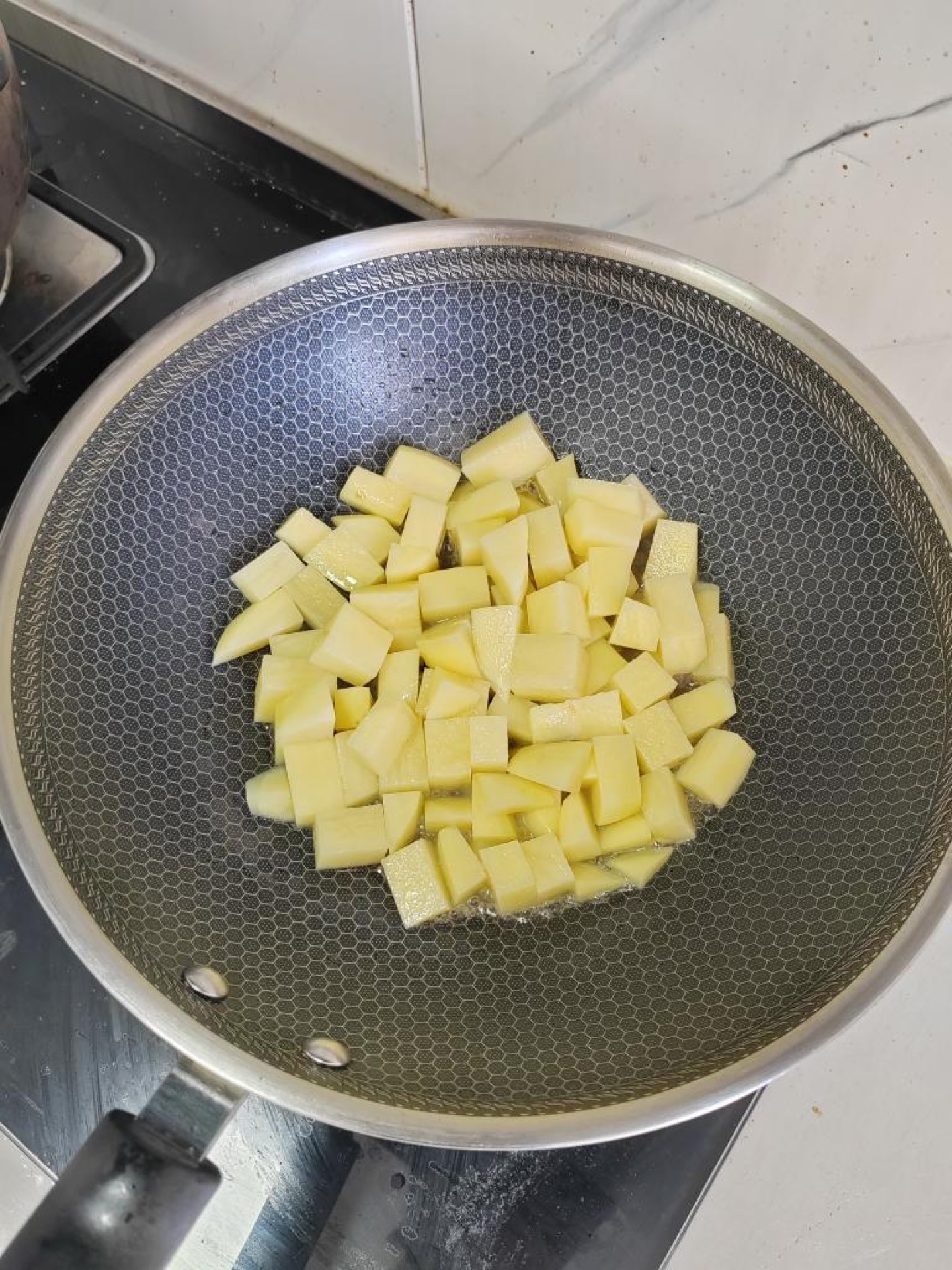 Potato cubes browning in a hot pan