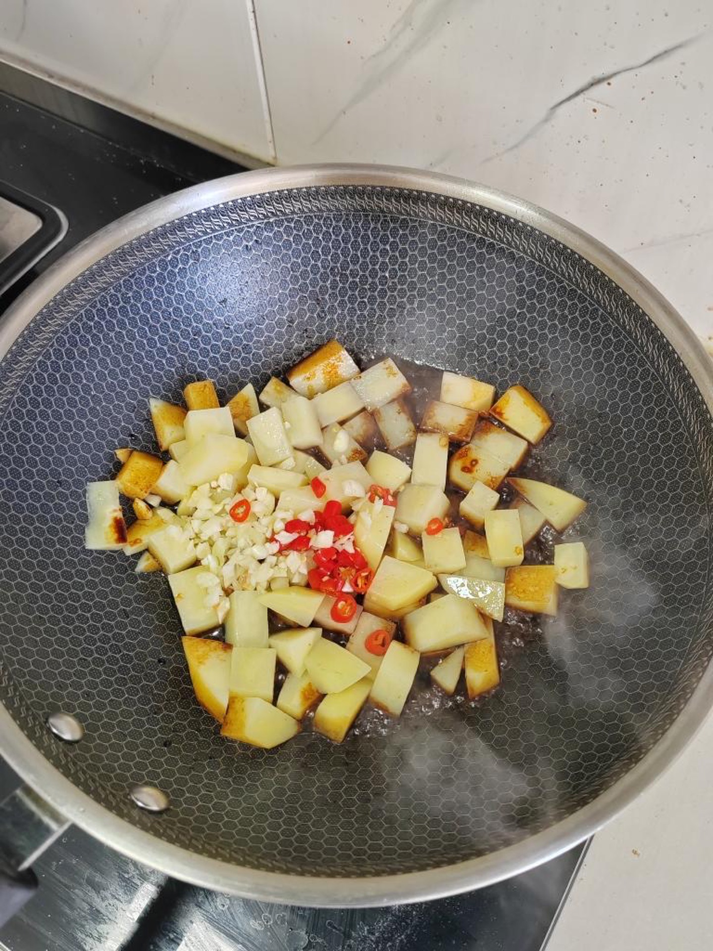 Garlic and chilies blooming in oil with soy sauce