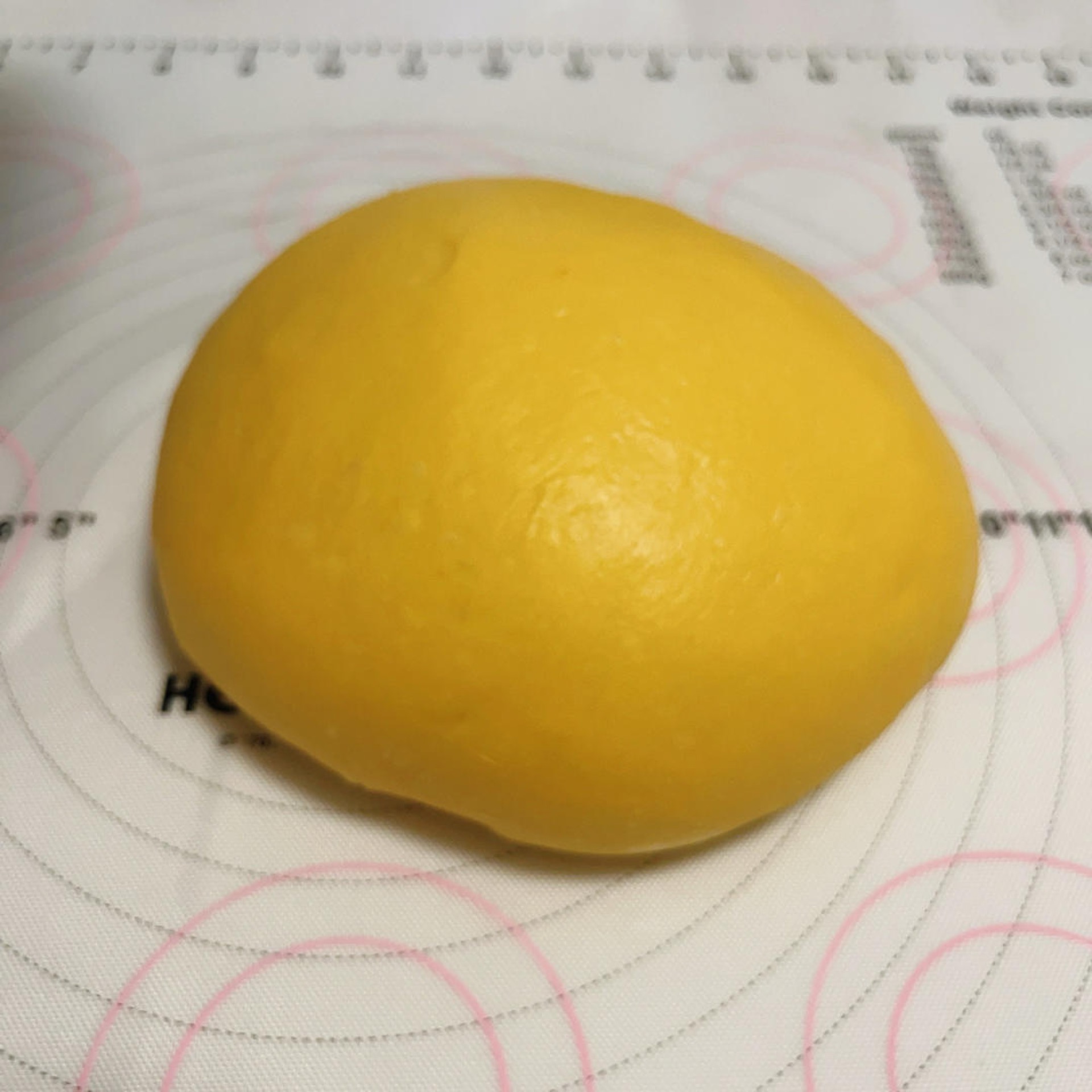 Two rounded balls of pumpkin dough resting under cover