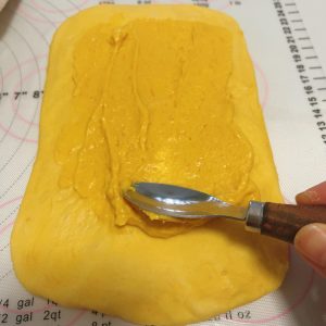 Pumpkin cream cheese filling piped over the dough rectangle