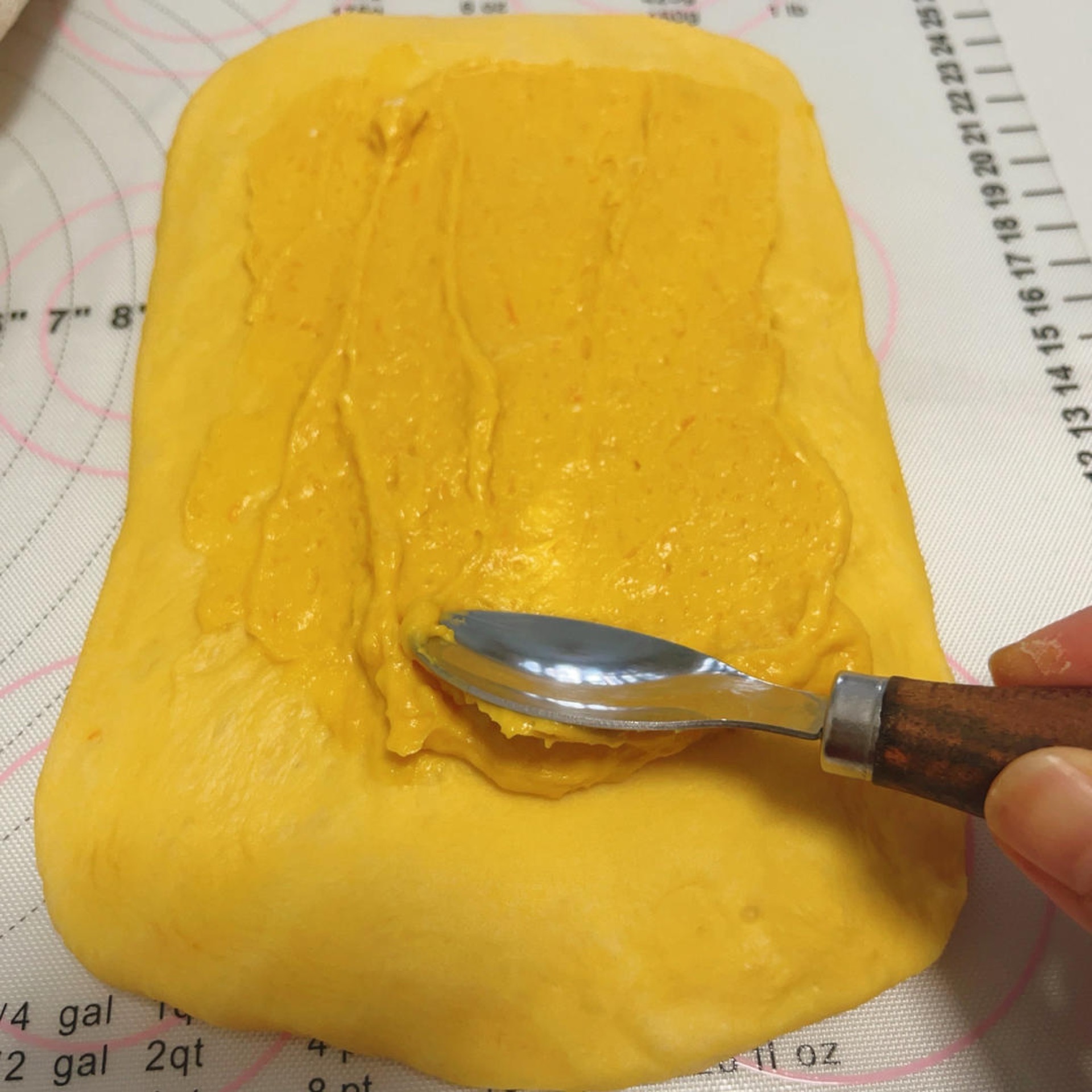 Pumpkin cream cheese filling piped over the dough rectangle