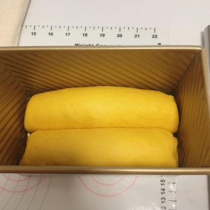 Two filled dough logs sitting side by side in the loaf pan