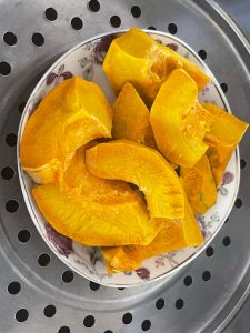 Steamed kabocha pumpkin scooped and weighed on the scale